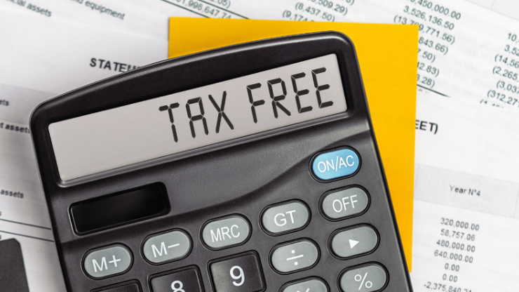 Close-up of a calculator displaying 'TAX FREE' with financial statements in the background, highlighting tax-free vouchers in Ireland.