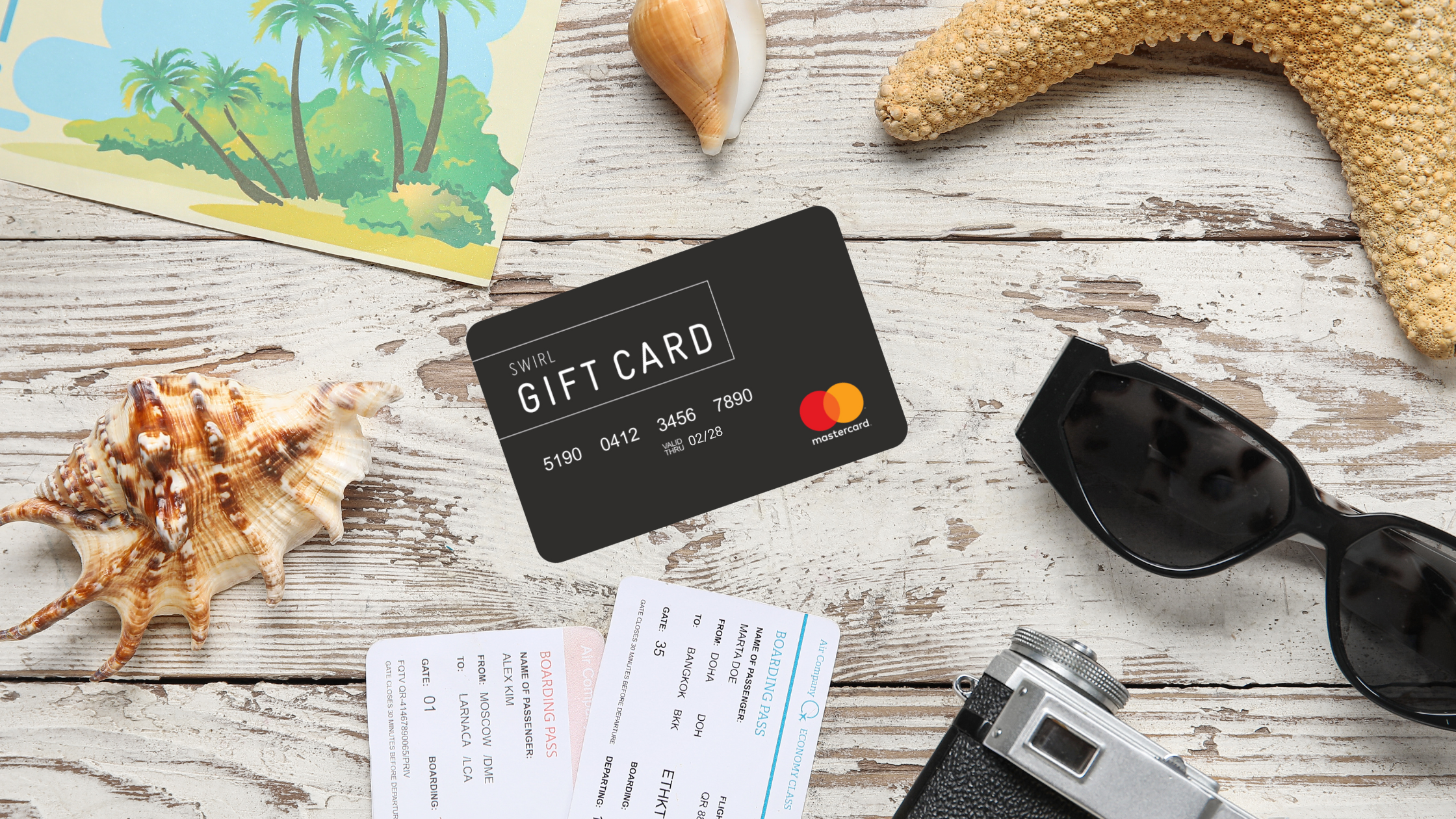 A black SWIRL Gift Card lying amidst travel essentials including boarding passes, a starfish, sunglasses, and a camera on a rustic wooden surface, suggesting preparation for a journey.