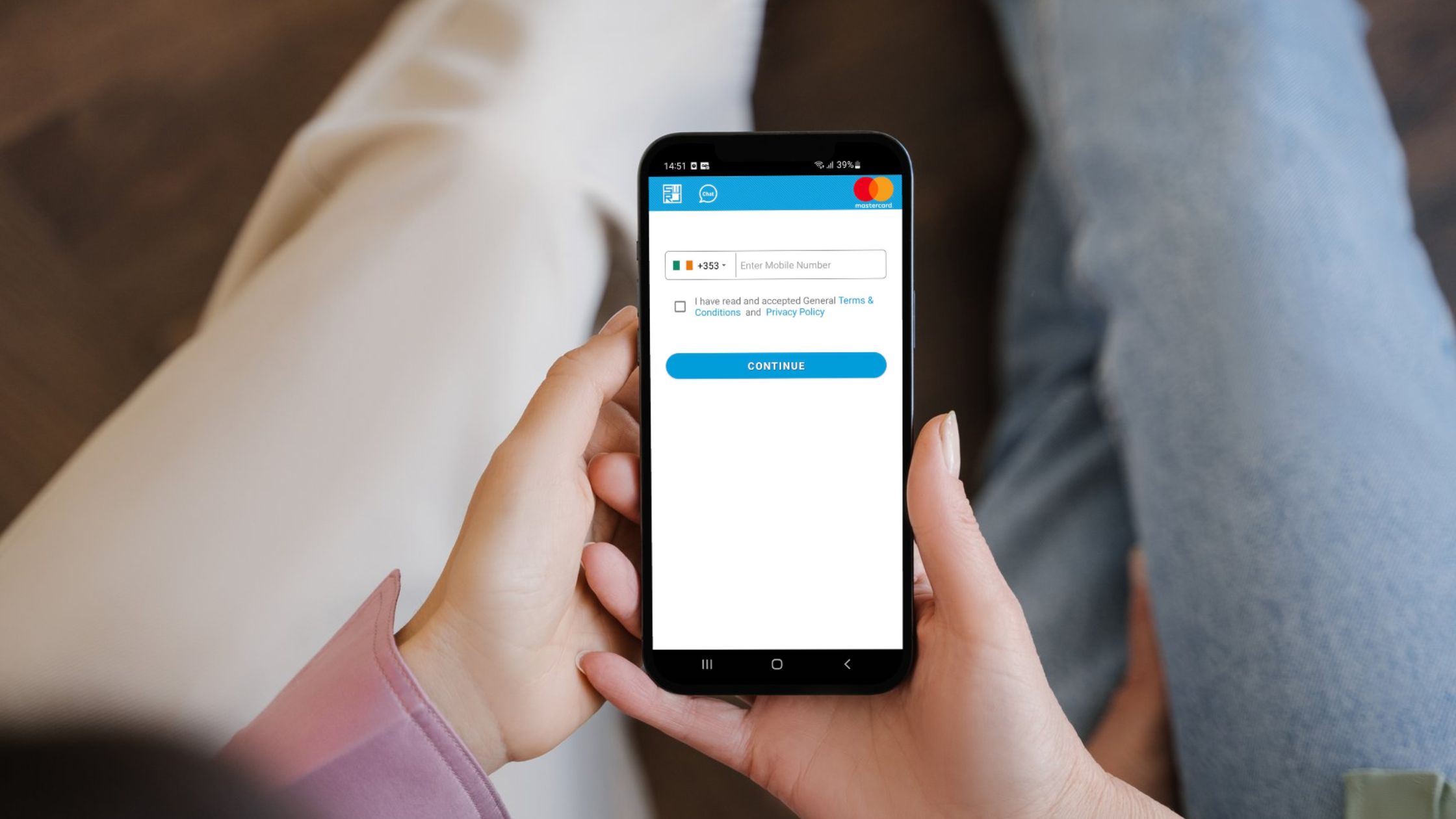 A person holding a smart phone while registering for a SWIRL Prepaid Mastercard via the SWIRL App